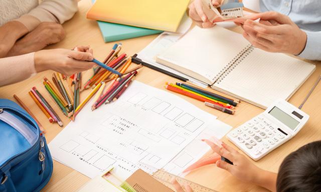 子どもの学用品と家計ノートを囲んで教育費を考える家庭